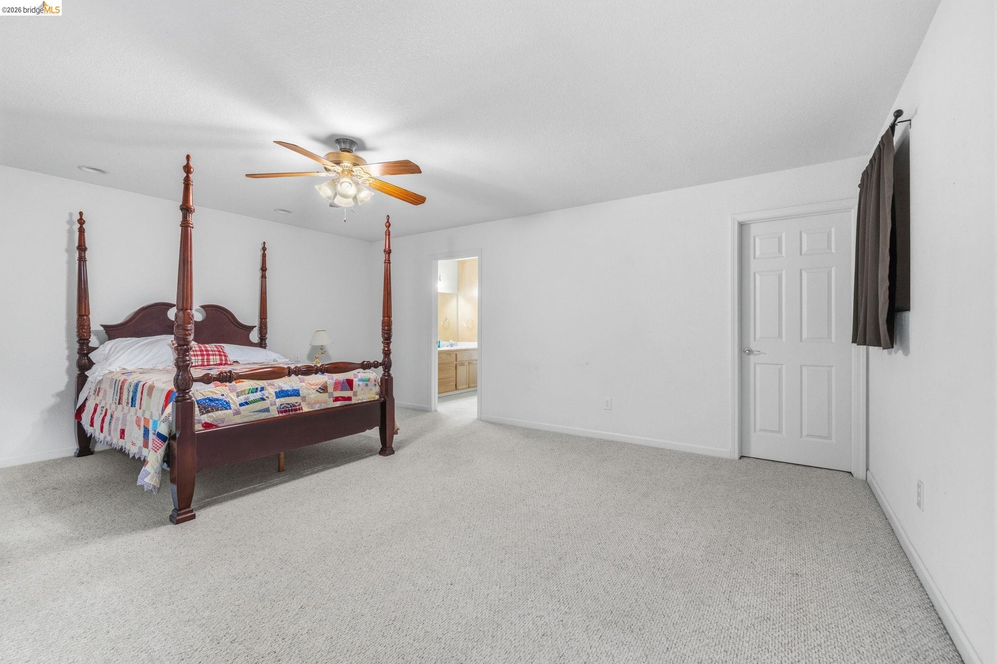 18450 Lambert Lake Road Sonora, CA 95370 - Photo 58 of 87 Carpeted room with a ceiling fan, white walls, and a paneled door