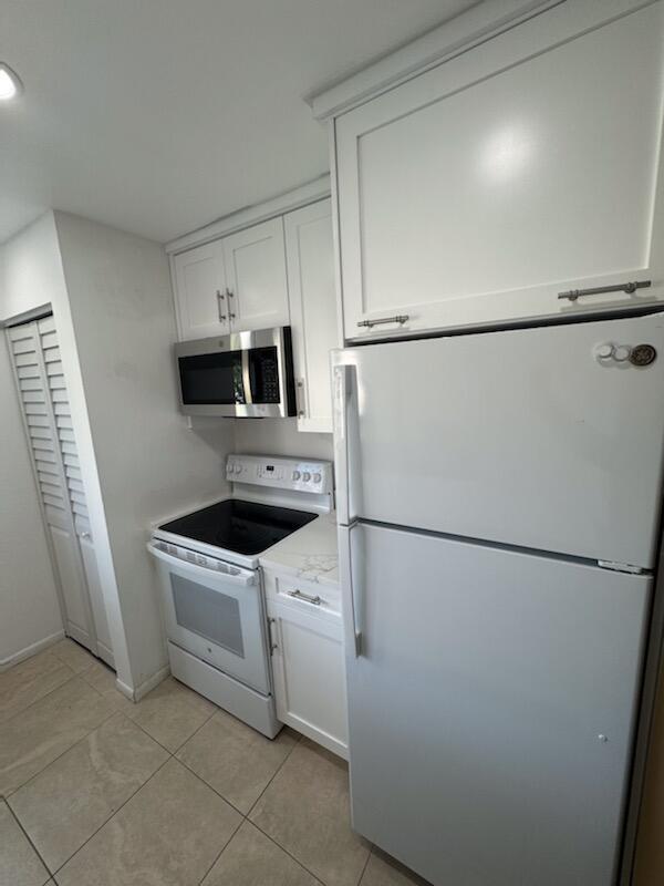 353 Highway 1, Unit A203 Jupiter, FL 33477 - Photo 14 of 26 a white refrigerator freezer and a stove sitting inside of a kitchen