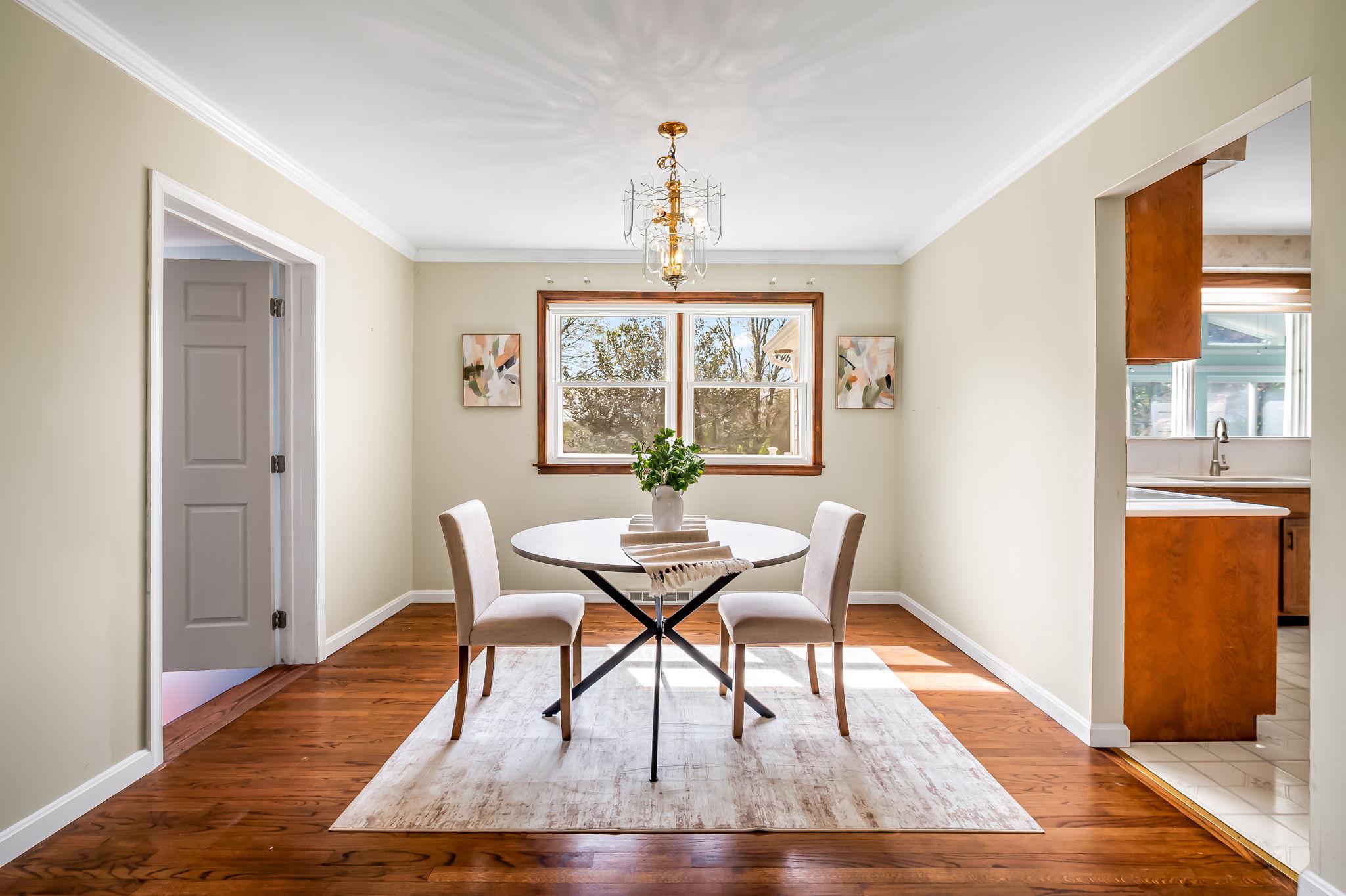 2619 Bradenbaugh Road White Hall, MD 21161 - Photo 11 of 50 a dining room with wooden floor a chandelier a wooden table and chairs