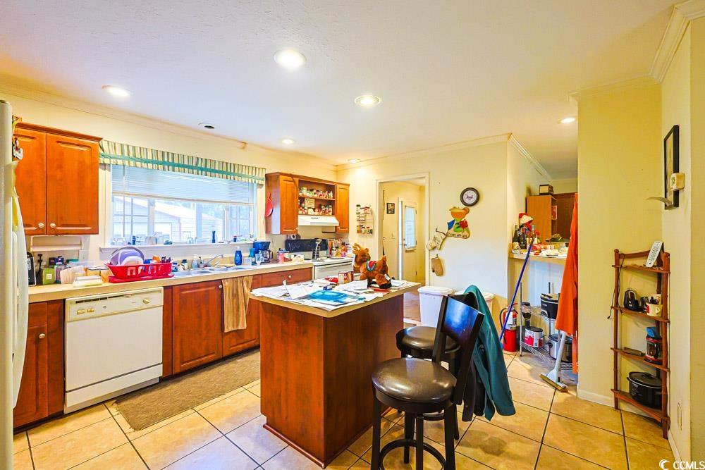 1291 Highway 701 Highway Loris, SC 29569 - Photo 9 of 40 Kitchen with a kitchen island, light countertops, crown molding, white appliances, and light tile patterned floors