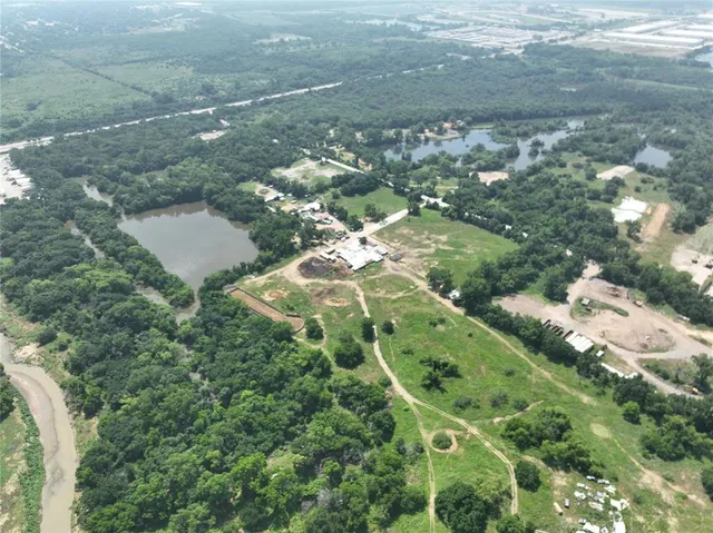 an aerial view of a residential houses with outdoor space and river