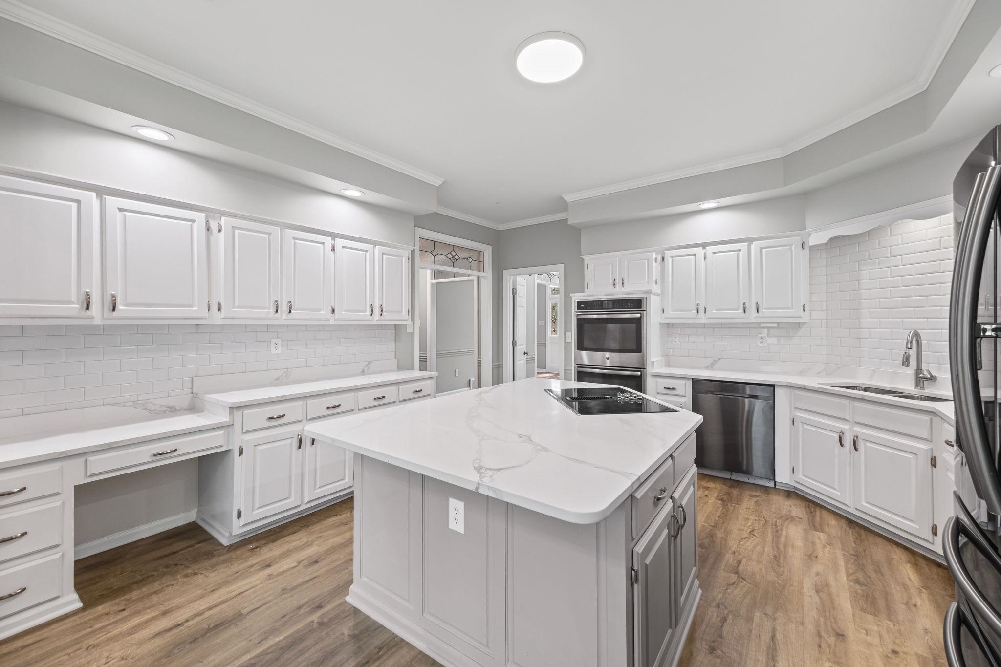 9190 East Bridge Drive Germantown, TN 38139 - Photo 13 of 37 Kitchen with crown molding, white cabinetry, tasteful backsplash, light wood-style flooring, and light stone countertops
