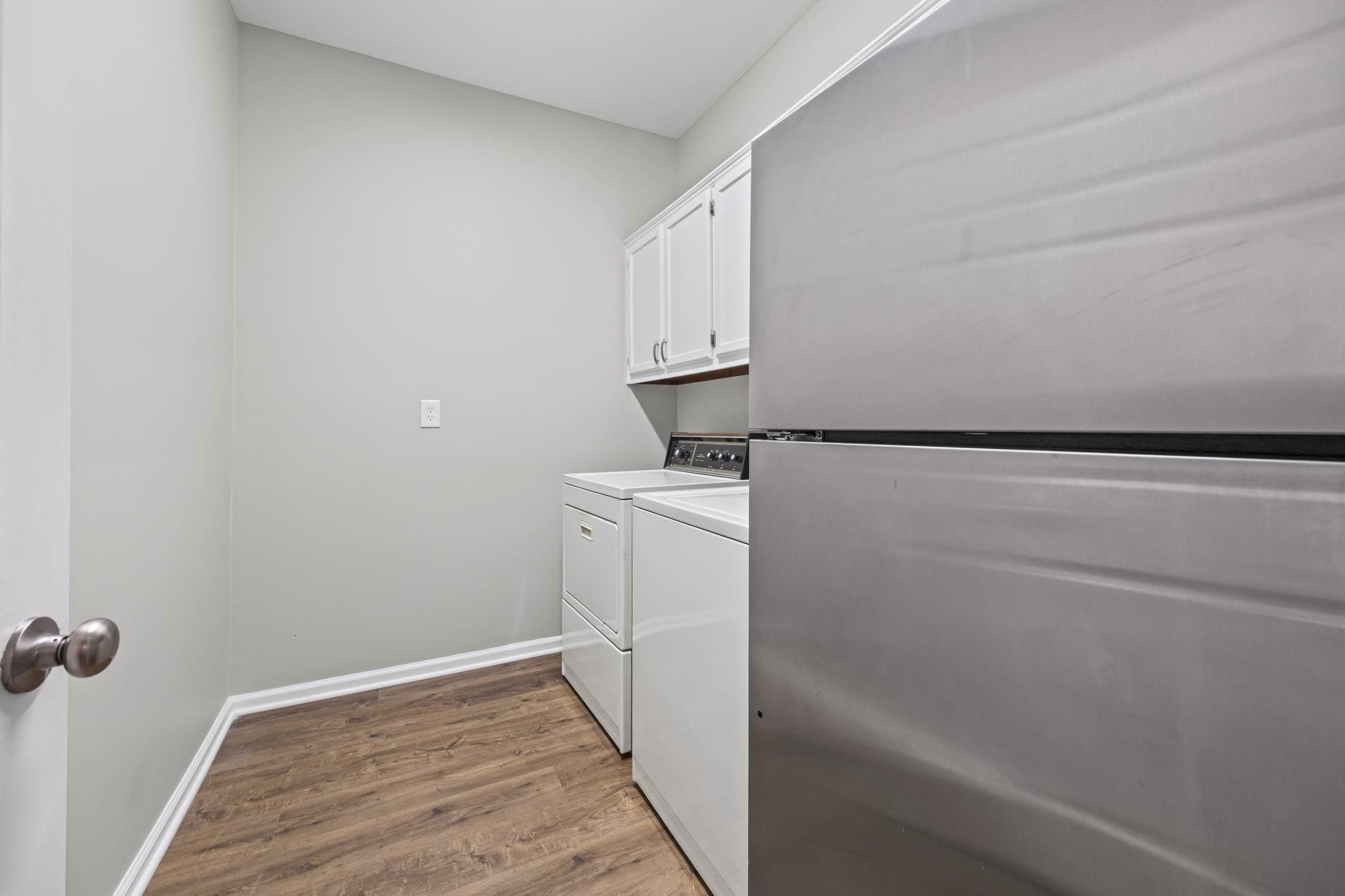 9190 East Bridge Drive Germantown, TN 38139 - Photo 17 of 37 Laundry area featuring dark wood finished floors, cabinet space, and washer and clothes dryer