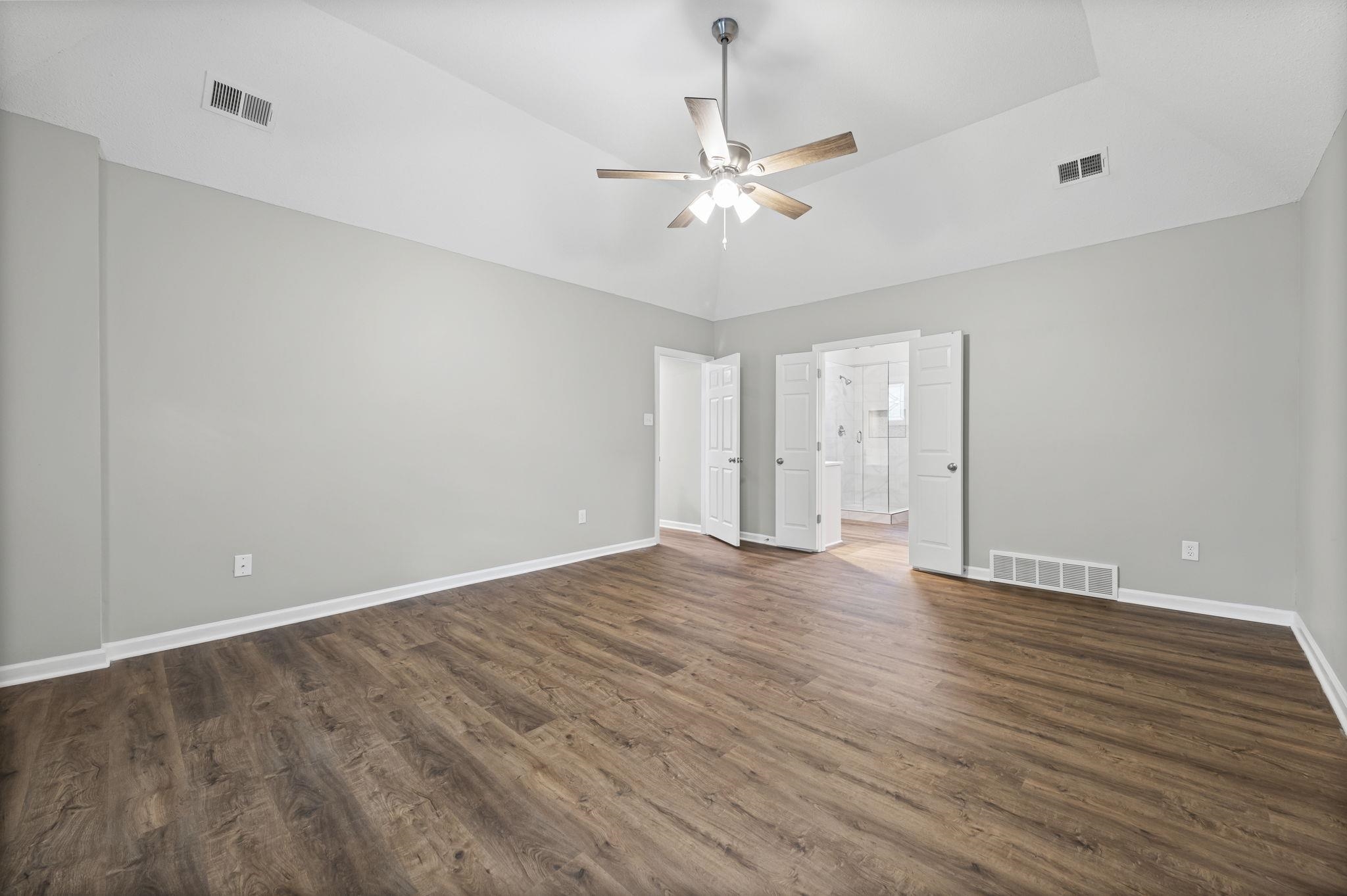 9190 East Bridge Drive Germantown, TN 38139 - Photo 20 of 37 Unfurnished bedroom featuring dark wood-style floors, ceiling fan, lofted ceiling, and connected bathroom