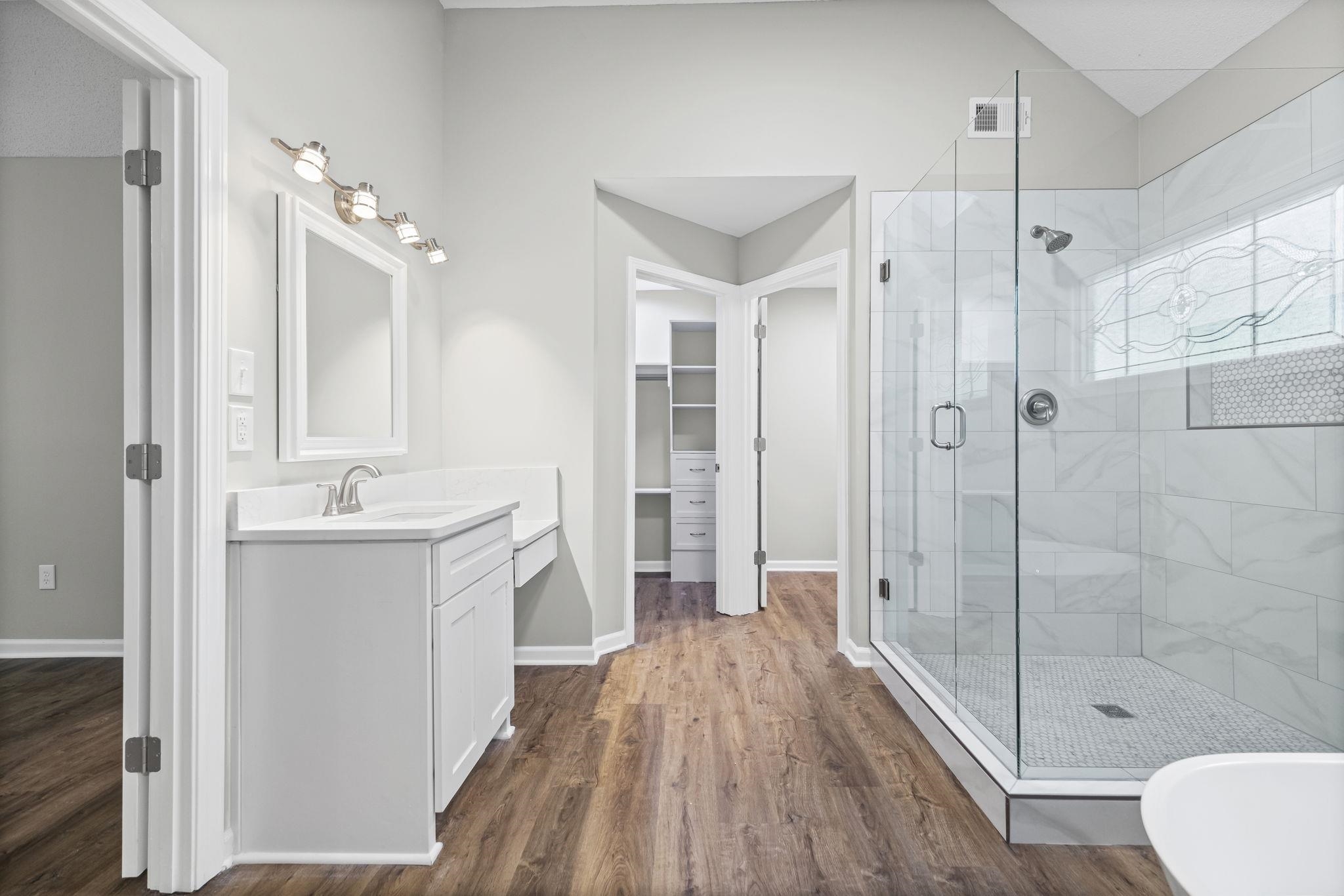 9190 East Bridge Drive Germantown, TN 38139 - Photo 22 of 37 Bathroom featuring a stall shower, vanity, dark wood-style floors, and a spacious closet