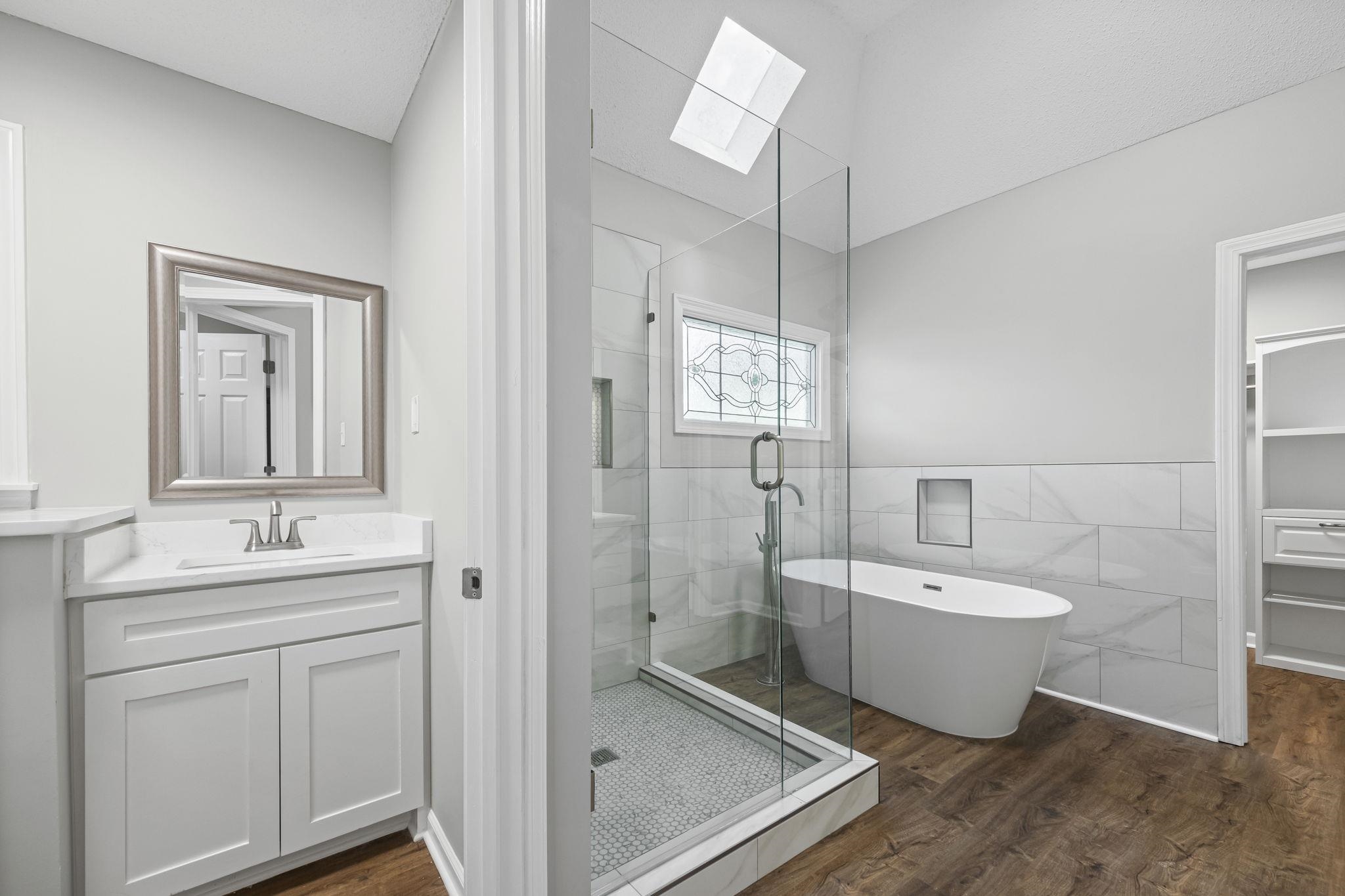 9190 East Bridge Drive Germantown, TN 38139 - Photo 24 of 37 Bathroom with a skylight, a shower stall, vanity, a freestanding bath, and dark wood finished floors