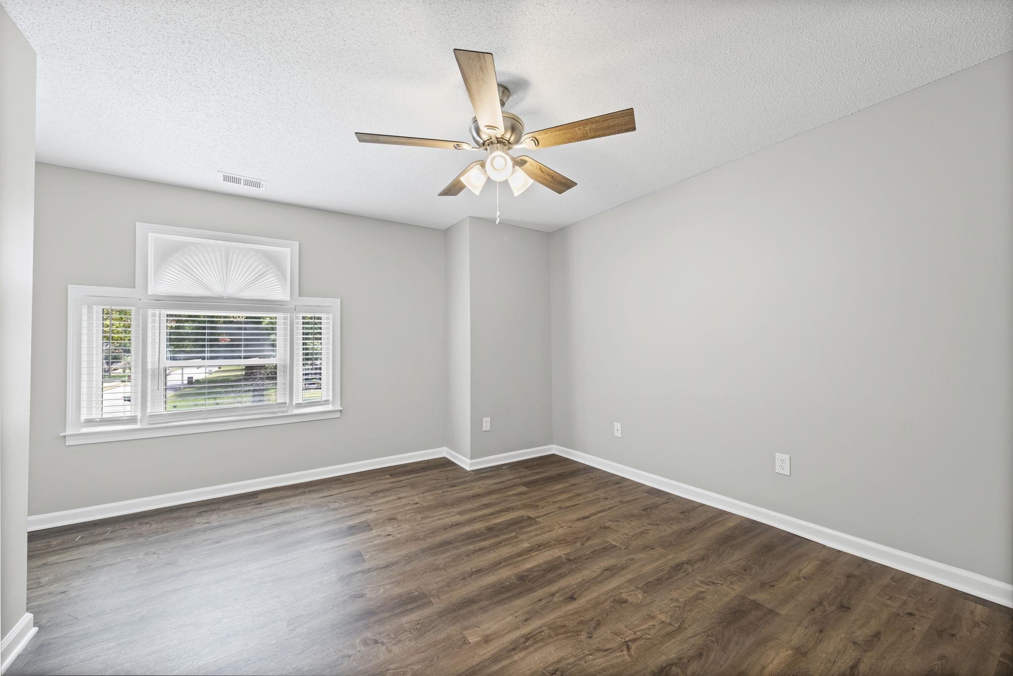9190 East Bridge Drive Germantown, TN 38139 - Photo 26 of 37 Unfurnished room featuring a textured ceiling, dark wood-type flooring, and a ceiling fan