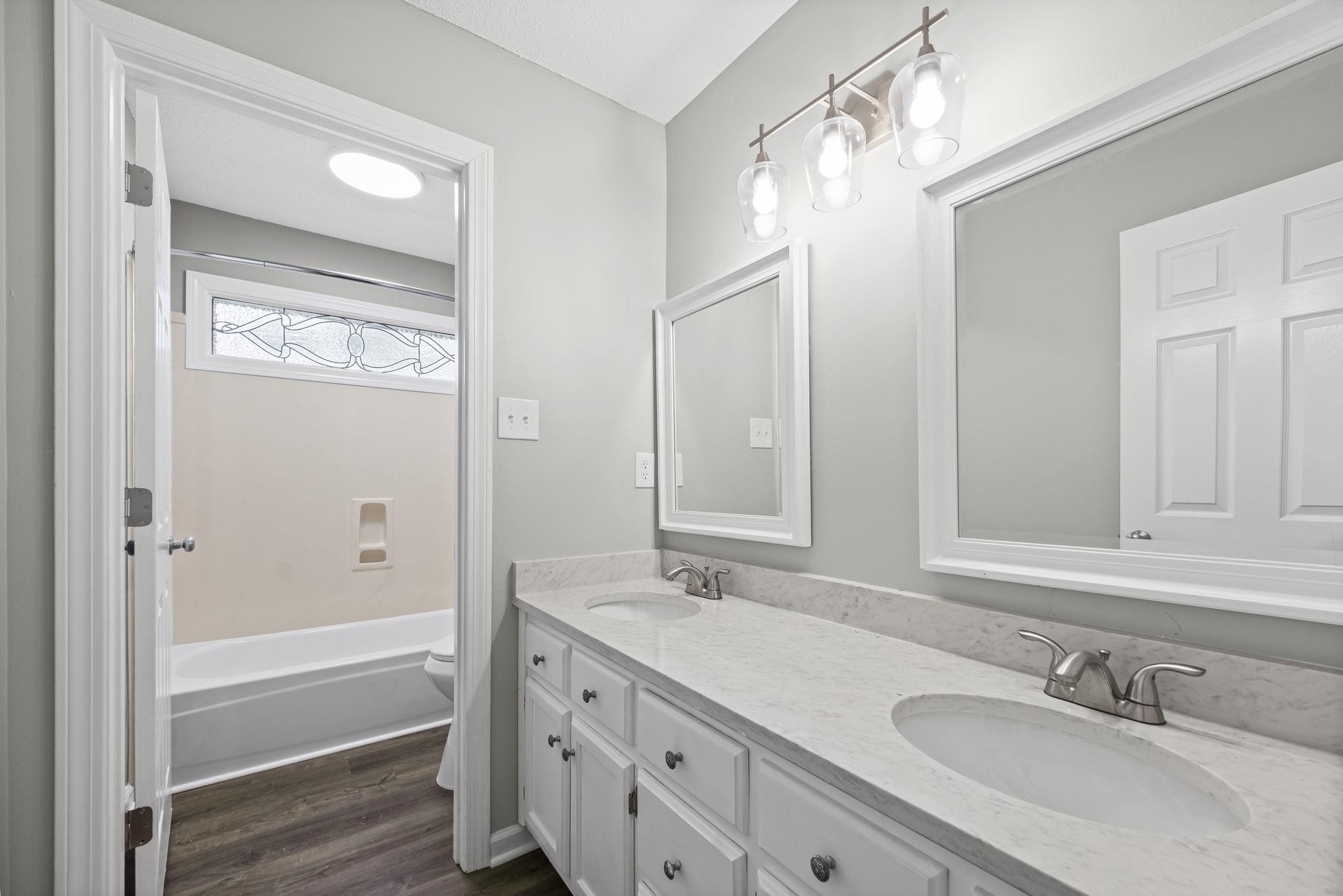 9190 East Bridge Drive Germantown, TN 38139 - Photo 30 of 37 Full bath featuring double vanity, dark wood-style floors, and shower / bath combination