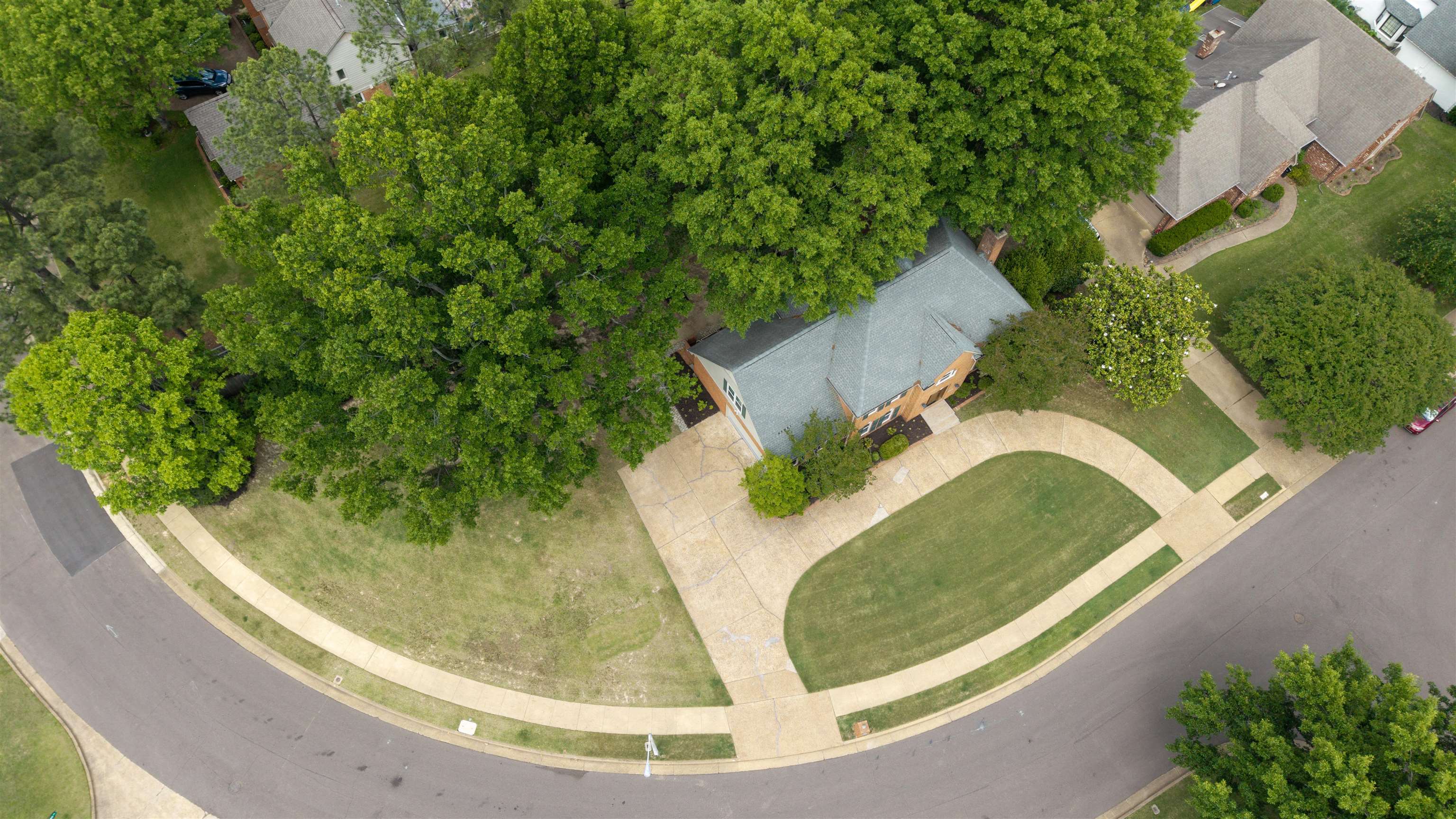 9190 East Bridge Drive Germantown, TN 38139 - Photo 3 of 37 Brick residence featuring a gabled roof and surrounding mature trees