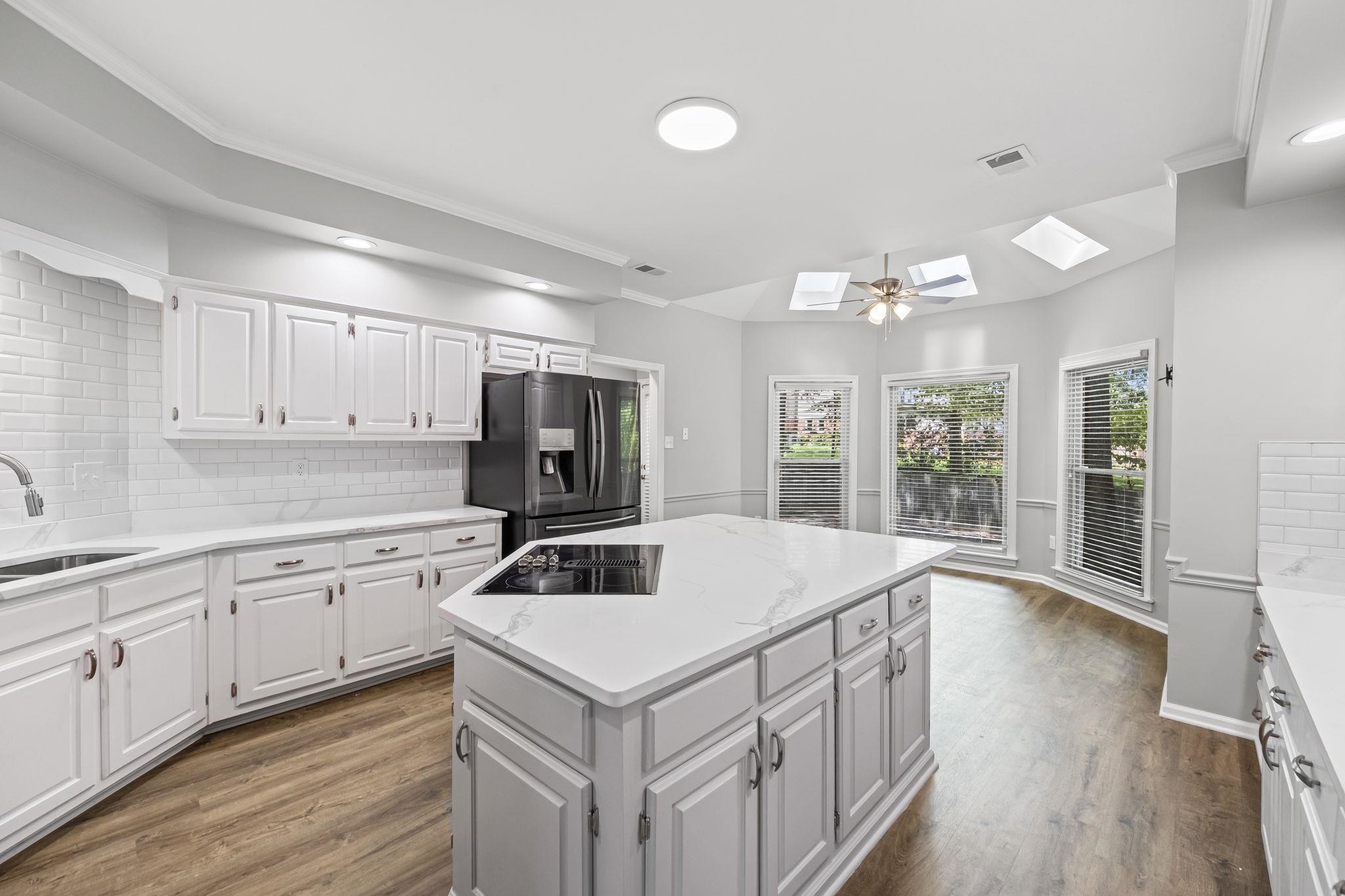 9190 East Bridge Drive Germantown, TN 38139 - Photo 9 of 37 Kitchen with tasteful backsplash, a skylight, white cabinets, dark wood-type flooring, and recessed lighting
