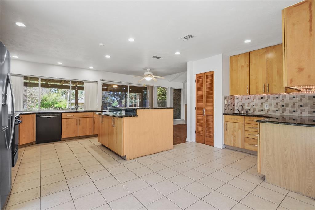 15721 Mapleview Circle Dallas, TX 75248 - Photo 11 of 40 a kitchen with stainless steel appliances kitchen island granite countertop a refrigerator and a stove top oven
