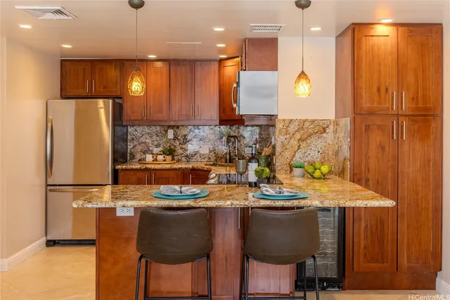 a kitchen with stainless steel appliances granite countertop a sink refrigerator and cabinets
