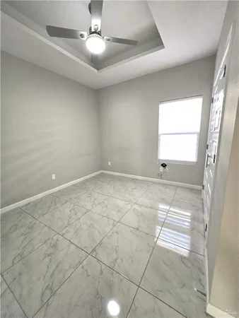 an empty room with windows and fan