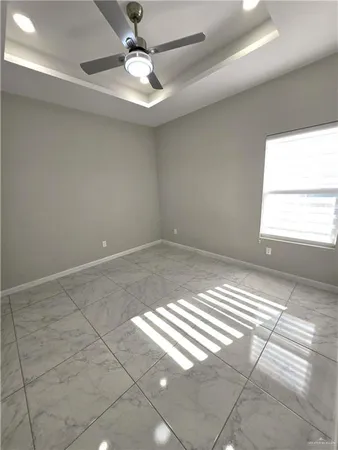 en empty room with windows and ceiling fan