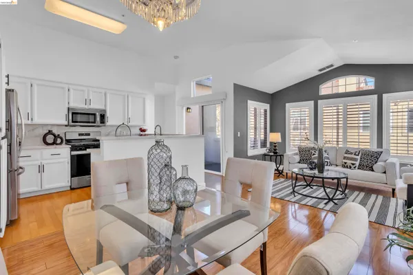 a living room with furniture a dining table and a chandelier