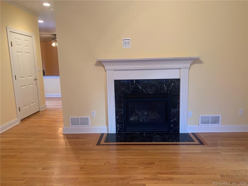 5 Pondview Circle, Unit 5 Beacon Falls, CT 06403 - Photo 9 of 18 a view of an empty room with wooden floor and a fireplace