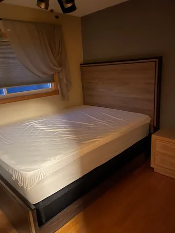 a bed sitting in a bedroom next to a window