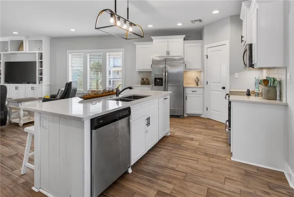 a kitchen with a sink a counter top space stainless steel appliances and cabinets