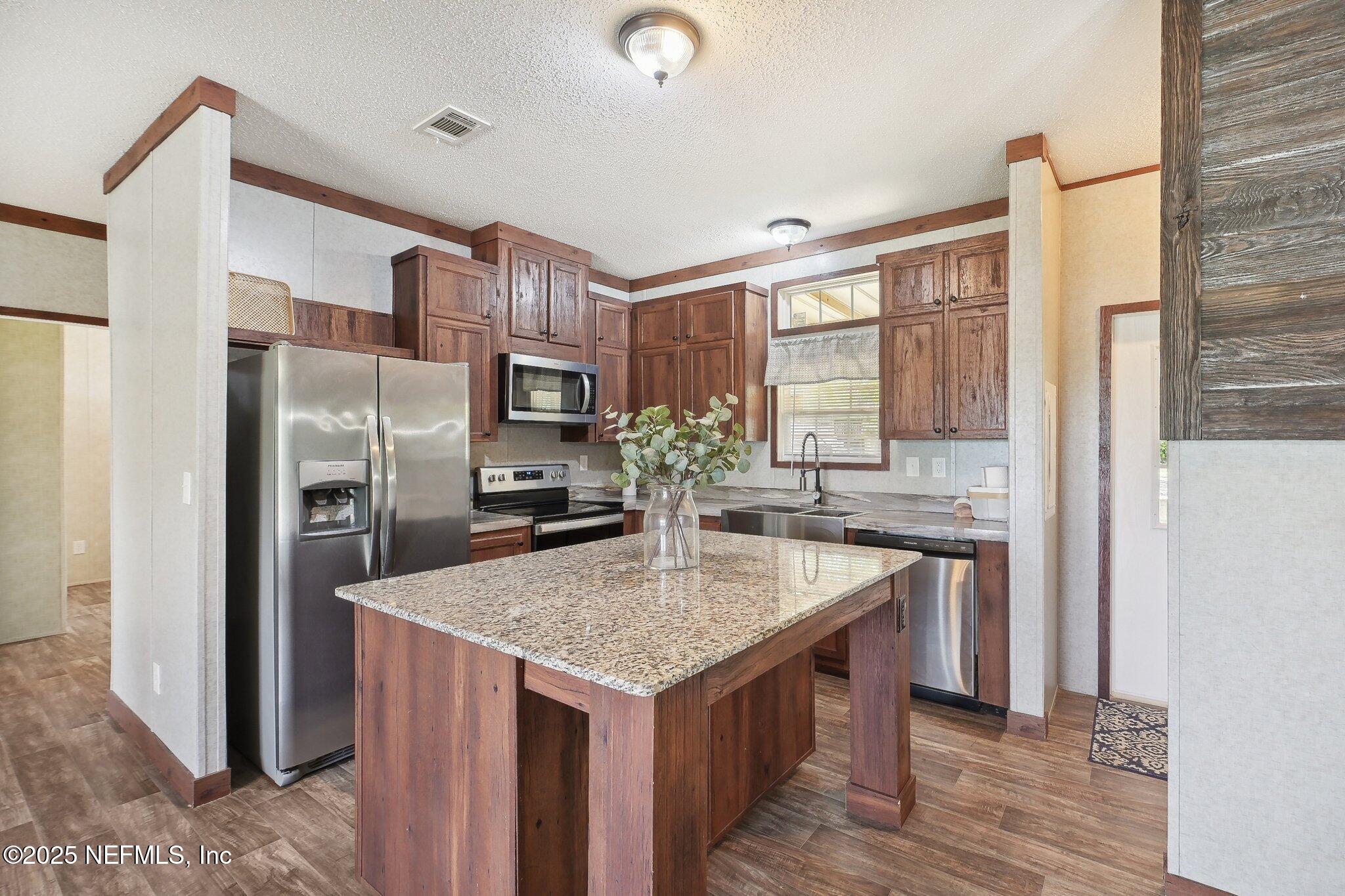 8145 Colee Cove Road St. Augustine, FL 32092 - Photo 14 of 35 a kitchen with stainless steel appliances granite countertop a kitchen island a stove and a refrigerator