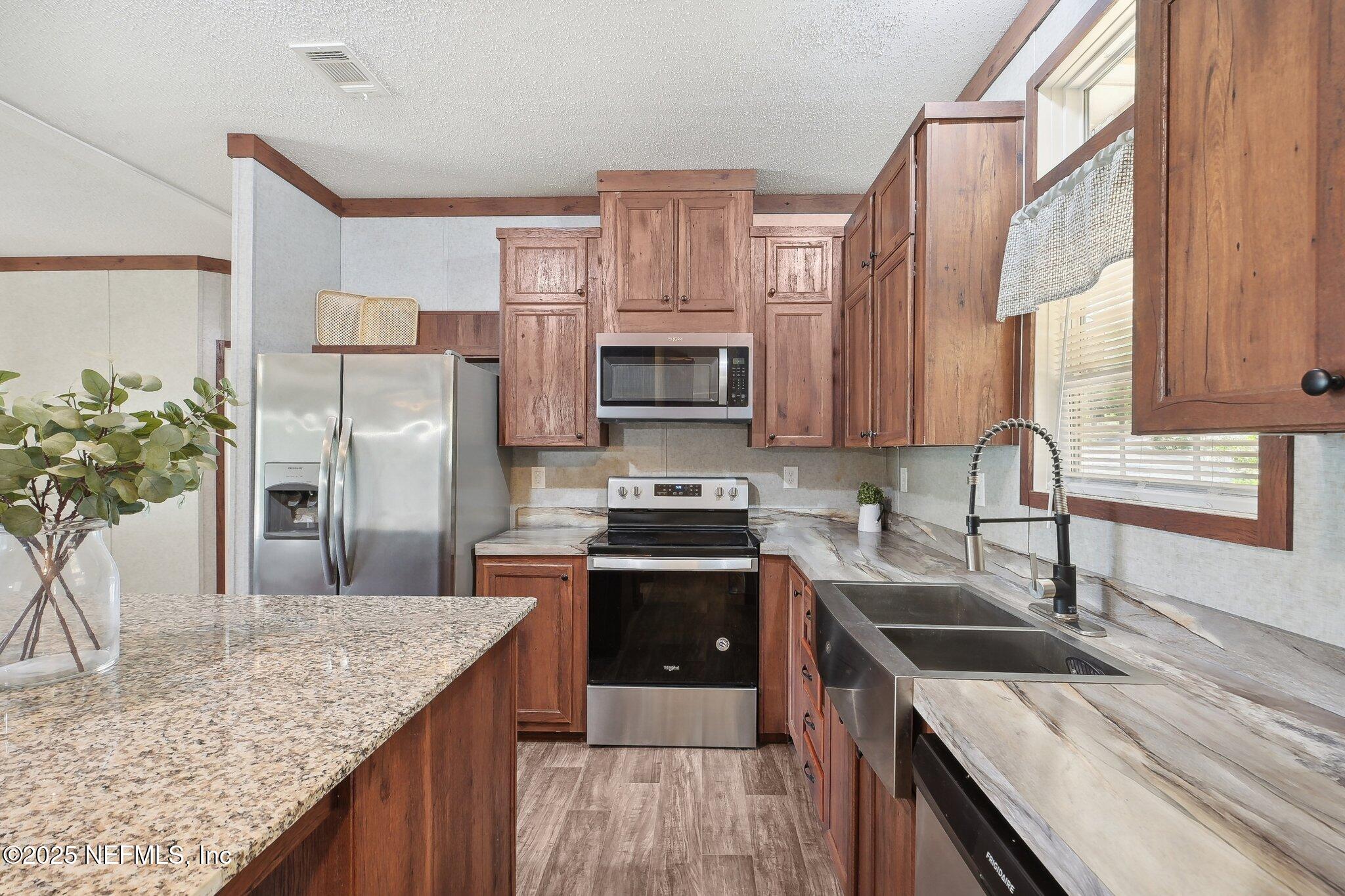 8145 Colee Cove Road St. Augustine, FL 32092 - Photo 15 of 35 a kitchen with stainless steel appliances granite countertop a kitchen island a stove a sink and a refrigerator