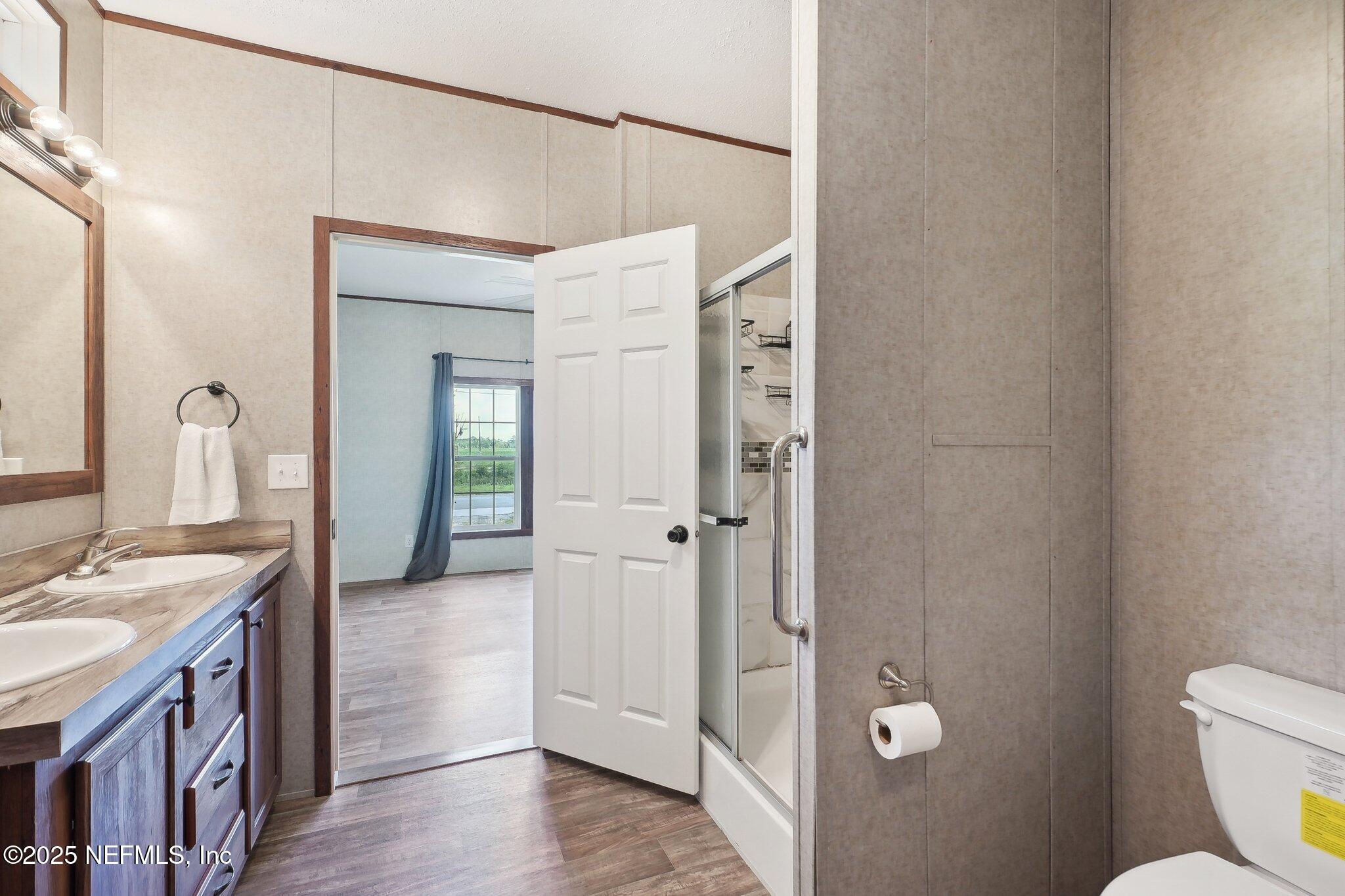 8145 Colee Cove Road St. Augustine, FL 32092 - Photo 19 of 35 a spacious bathroom with a granite countertop sink a toilet a mirror and shower