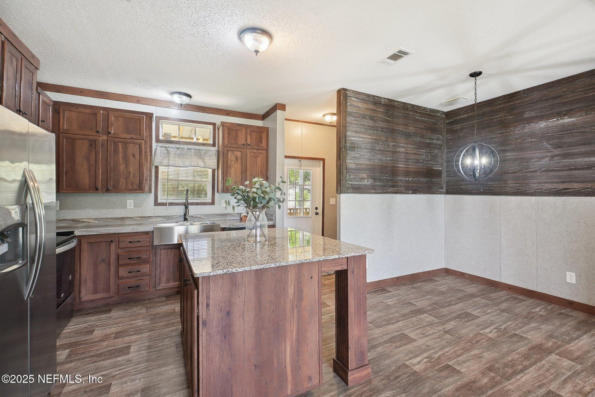8145 Colee Cove Road St. Augustine, FL 32092 - Photo 5 of 35 a kitchen with kitchen island a sink stove and refrigerator