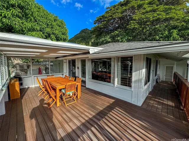 a view of a patio with table and chairs barbeque with wooden floor and fence