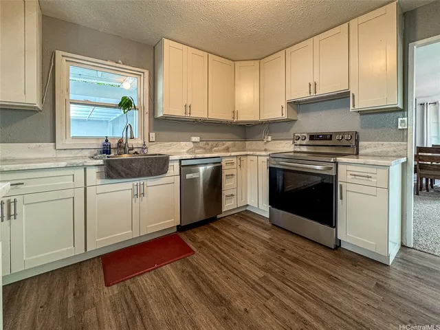 a kitchen with cabinets wooden floor and stainless steel appliances