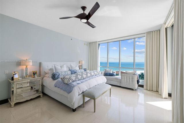 a living room with furniture and large windows