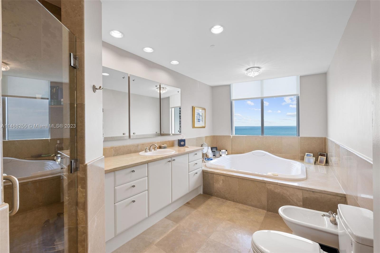 5959 Collins Avenue, Unit 902 Miami Beach, FL 33140 - Photo 18 of 46 a bathroom with a sink a tub and a mirror