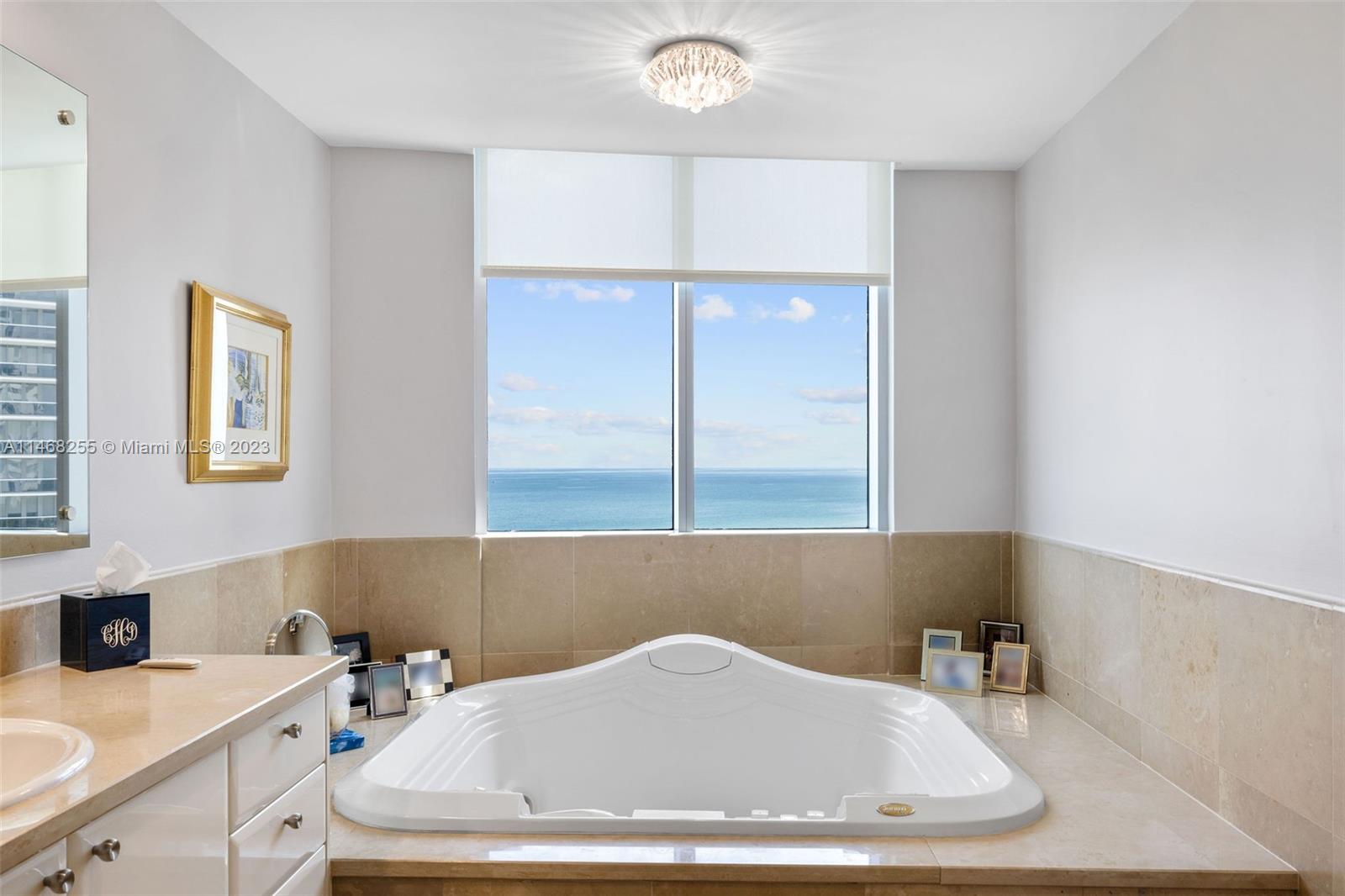 5959 Collins Avenue, Unit 902 Miami Beach, FL 33140 - Photo 19 of 46 a bathroom with a bathtub and next to a window