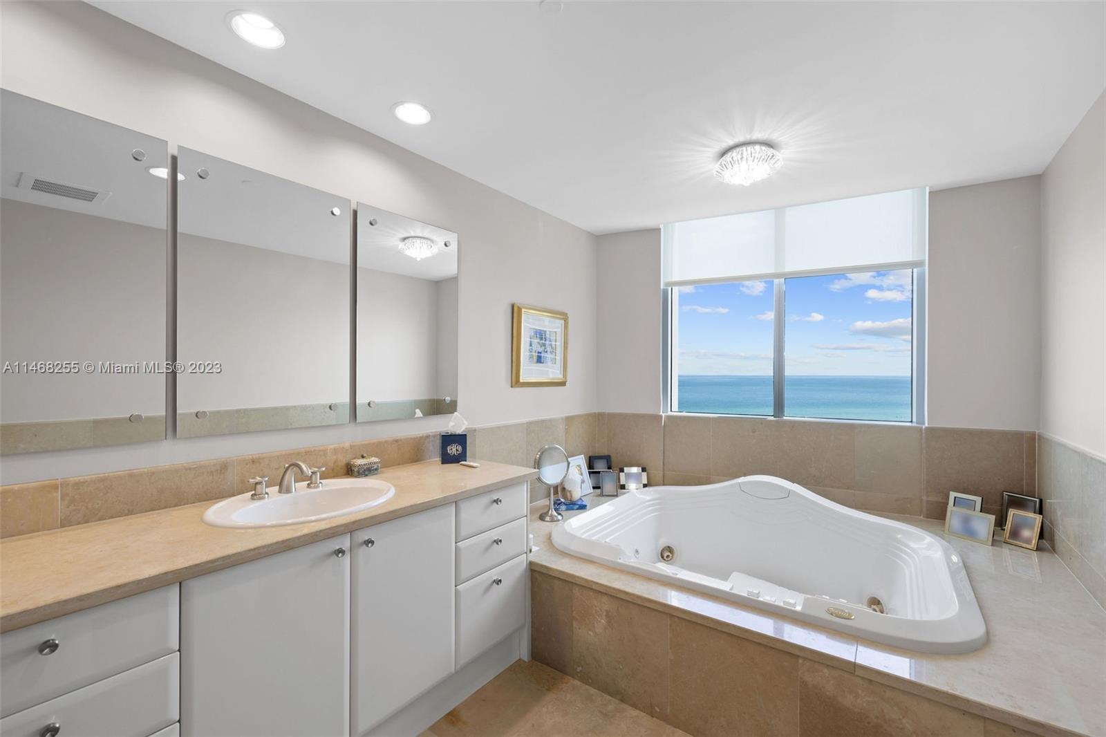 5959 Collins Avenue, Unit 902 Miami Beach, FL 33140 - Photo 20 of 46 a bathroom with a tub a sink and mirror