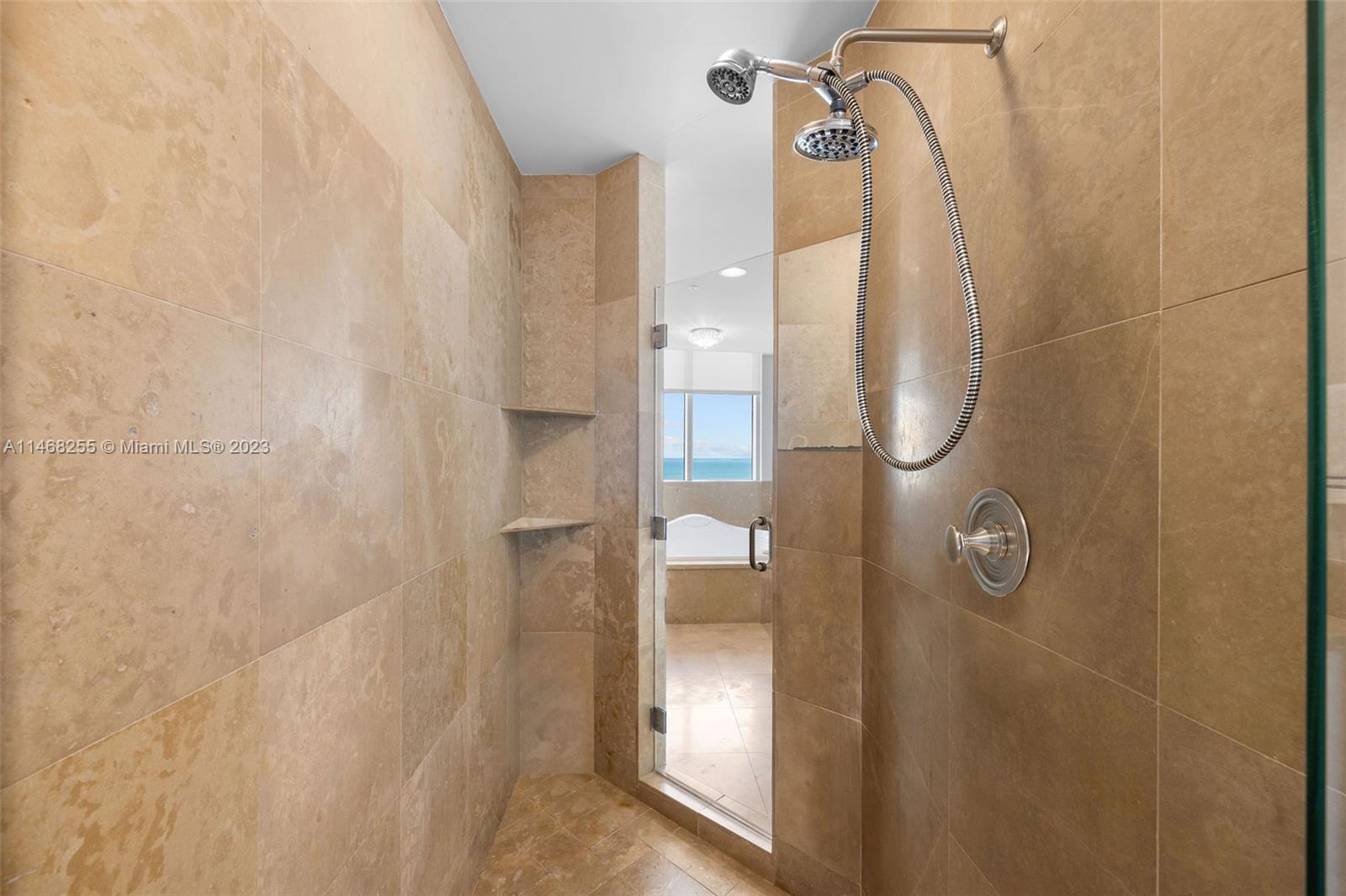 5959 Collins Avenue, Unit 902 Miami Beach, FL 33140 - Photo 21 of 46 a bathroom with a glass shower door
