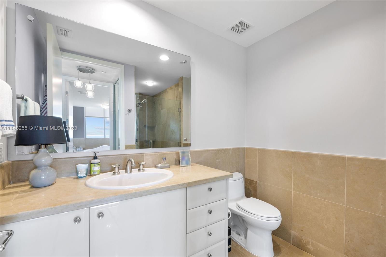 5959 Collins Avenue, Unit 902 Miami Beach, FL 33140 - Photo 23 of 46 a bathroom with a sink toilet and mirror