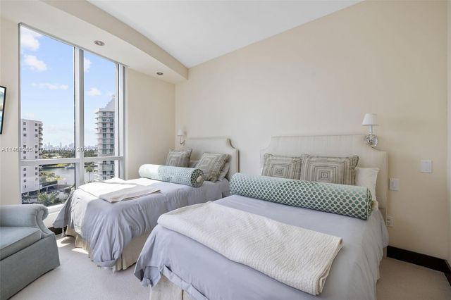 a bedroom with furniture and a large window