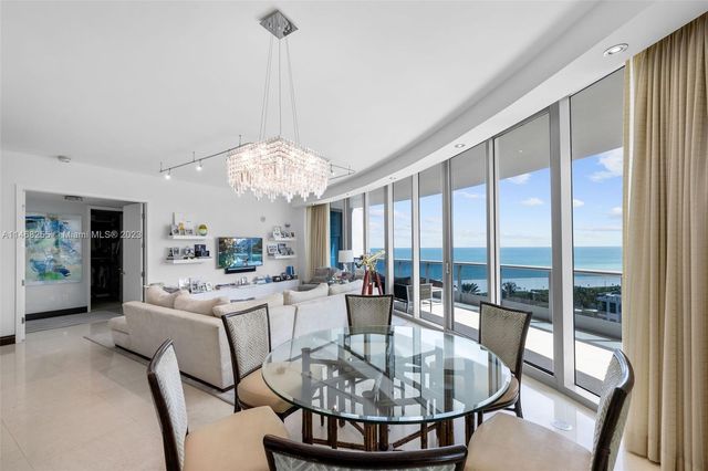 a dining room with furniture a chandelier and wooden floor