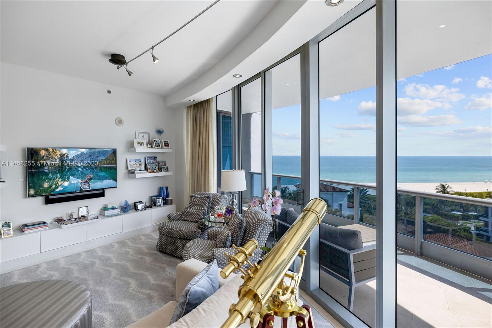 5959 Collins Avenue, Unit 902 Miami Beach, FL 33140 - Photo 6 of 46 a living room with furniture and a flat screen tv