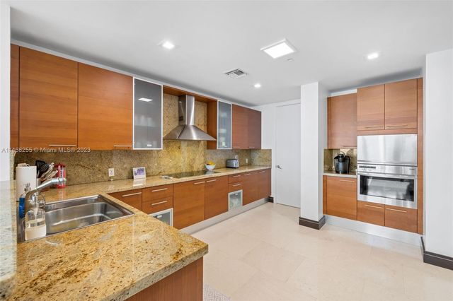 a kitchen with stainless steel appliances granite countertop a sink counter space cabinets and a large window