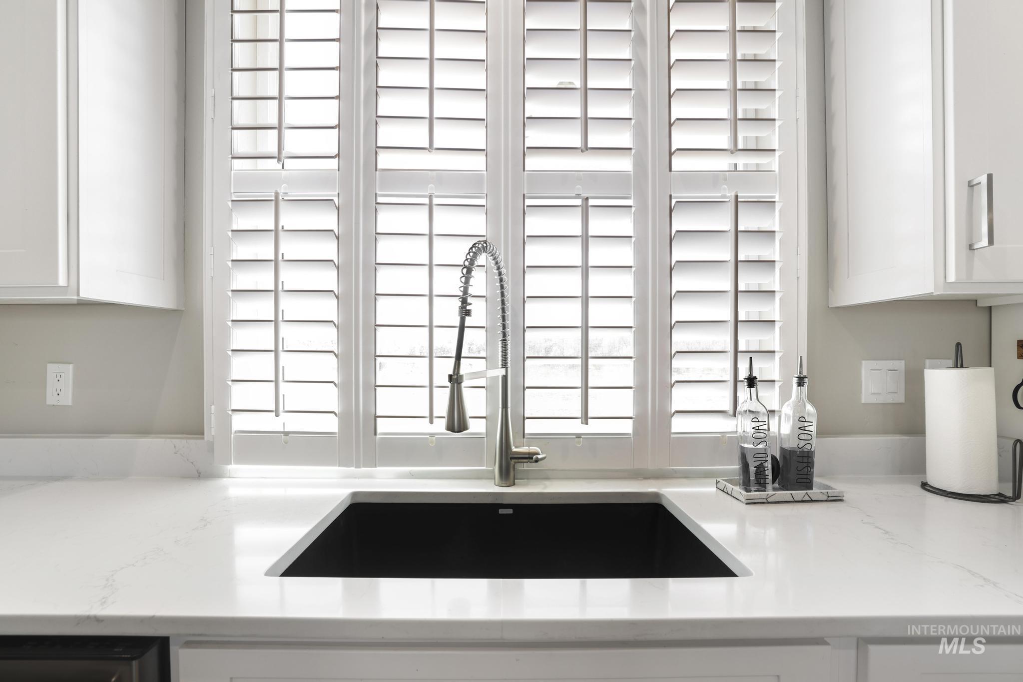 758 Cedar Crk Road Rogerson, ID 83302 - Photo 11 of 50 Kitchen sink area featuring a black undermount sink, a gooseneck faucet, and white countertops