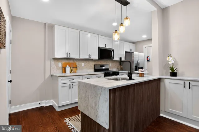 a kitchen with a sink a microwave and cabinets