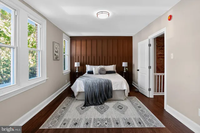 a bed sitting in a spacious bedroom next to a window