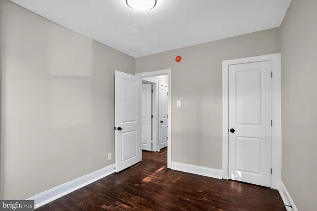 an empty room with wooden floor and entrance