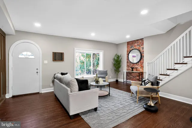 a living room with fireplace furniture and a wooden floor