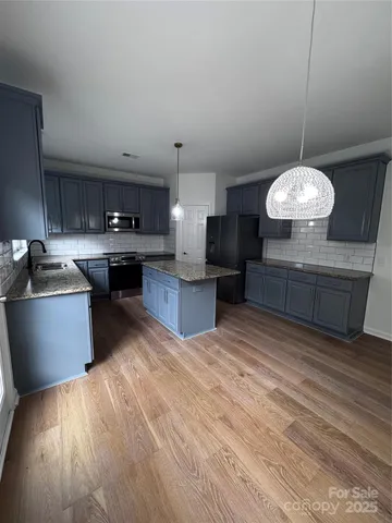 a kitchen with stainless steel appliances granite countertop a stove and a refrigerator