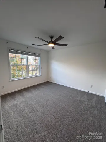 an empty room with windows and ceiling fan