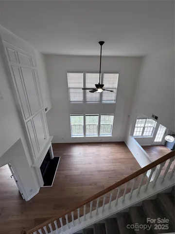 a view of an empty room with window and wooden floor