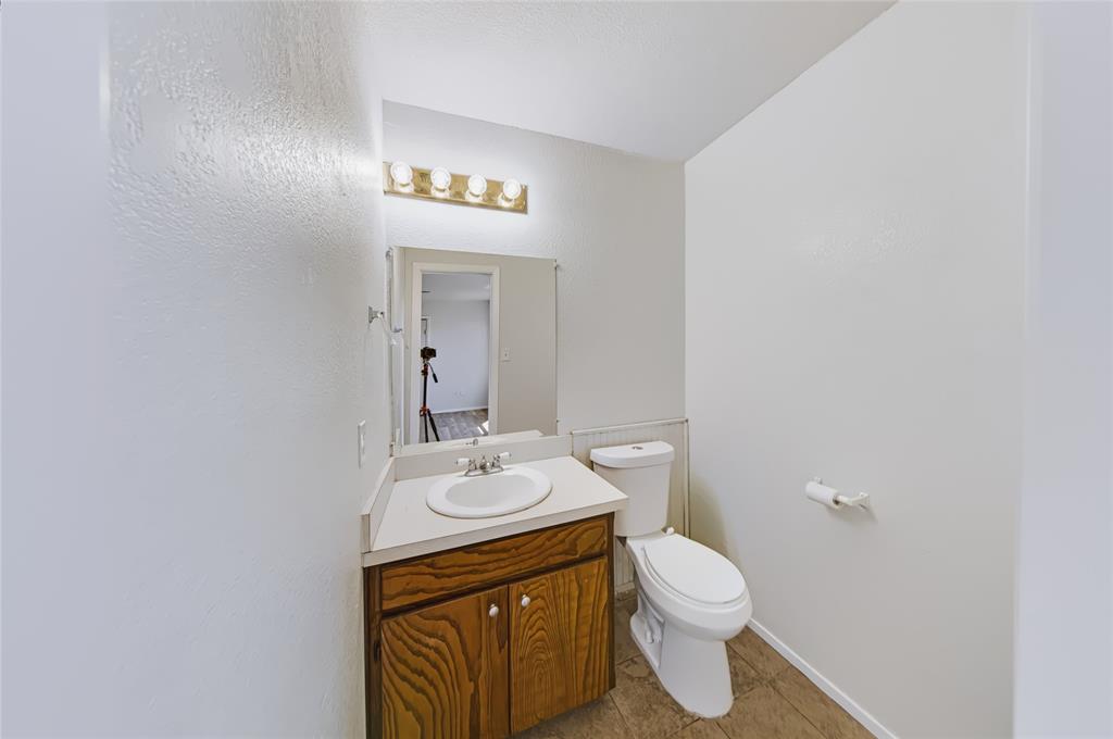 560 Green Acres Road Weatherford, TX 76088 - Photo 10 of 35 Vanity with wood-finish cabinetry and integrated sink