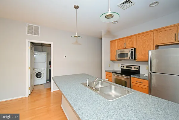 a kitchen with stainless steel appliances granite countertop a sink refrigerator and cabinets