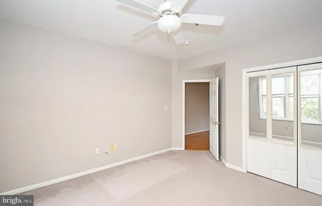 an empty room with a ceiling fan and a window