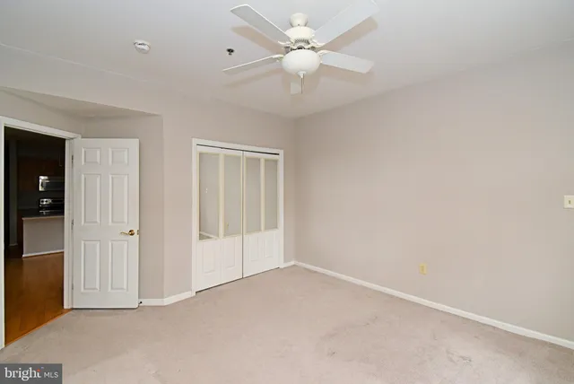 an empty room with a ceiling fan and a window